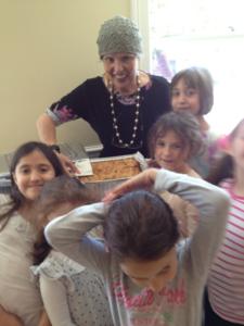 Woman with children and a baked dish.