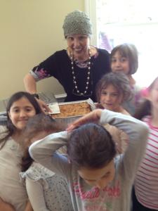 Woman and children with a baked dish.