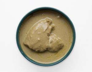 A bowl of peanut butter on top of a table.