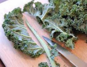 Kale leaves on cutting board with knife.