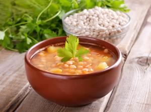 A bowl of soup and rice on the table.