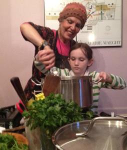 Woman and child cooking together in kitchen.