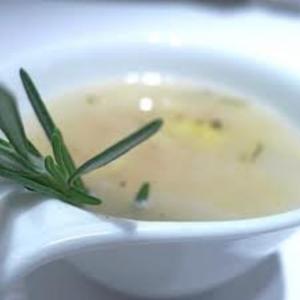 Bowl of soup with rosemary garnish.
