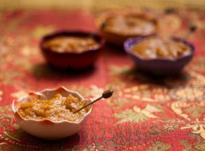 Bowls of chutney on decorative tablecloth.