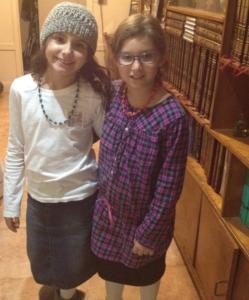 Two girls smiling in a library.