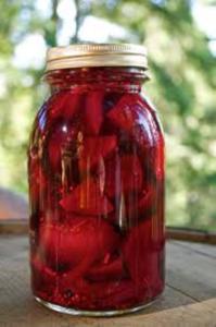 Jar of pickled beets on table outdoors.