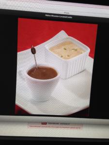 A cup of coffee and some crackers on a plate.