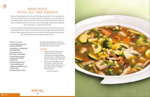 A bowl of soup with vegetables on the side.