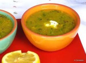 Two bowls of soup with lemon slice.