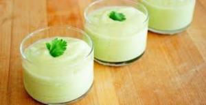 Three avocado mousse cups with cilantro garnish.