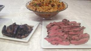 Pasta, grilled mushrooms, and sliced meat on plates.