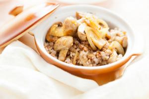 A bowl of food with meat and vegetables.
