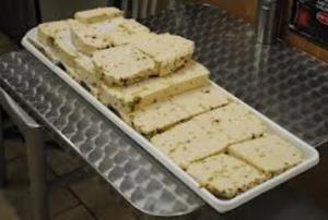 A tray of white cake squares on top of a table.