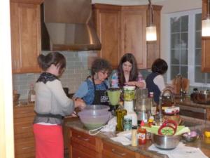A group of people in the kitchen preparing food.