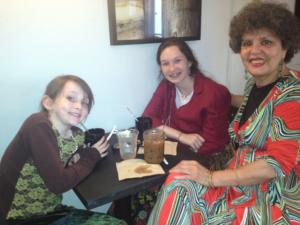 Three women sitting at a table with drinks.