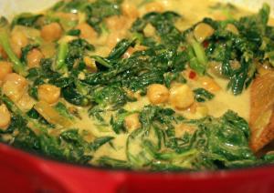 Creamy spinach and chickpea curry in red pot