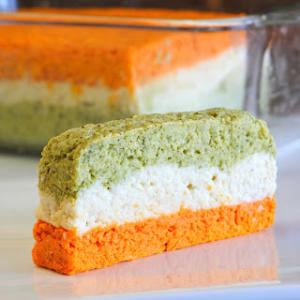 A piece of cake with green and orange frosting.