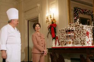 A woman standing in front of a table with a lot of christmas decorations.