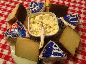 A bowl of macaroni and cheese surrounded by other snacks.