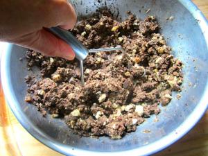 A person is stirring some food in a bowl.