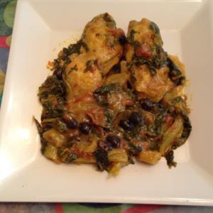 A white plate topped with food covered in sauce.