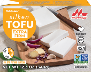 A package of tofu sitting on top of a cutting board.