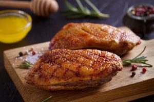 A close up of two pieces of meat on a cutting board