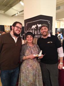 Three people standing in front of a sign.