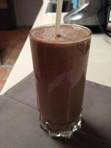 A chocolate smoothie is sitting on the table.