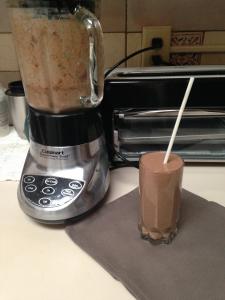 A blender and cup of coffee on the counter.