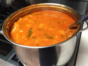 A pot of soup on the stove.