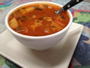 A bowl of soup on a white plate.