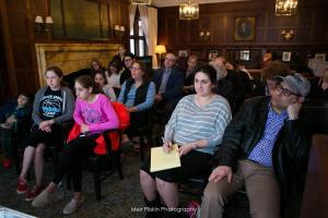 A group of people sitting in front of a wall.