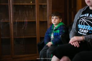A boy sitting on the couch with his father.