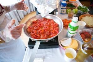 A person is cooking tomatoes in the kitchen.