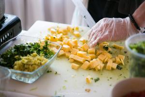 A person cutting up food on top of a table.