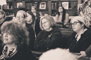 Women seated attentively in library meeting