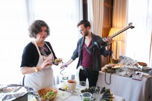 Two people standing in a kitchen preparing food.