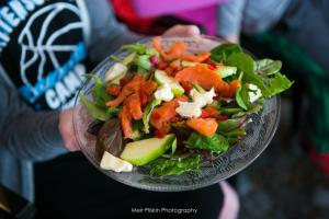 A bowl of salad with avocado and tomatoes.