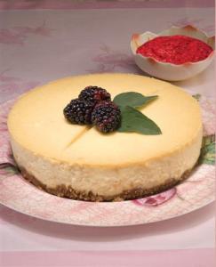 A cheesecake with blackberries on top of it.