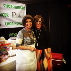 Two women standing next to each other in front of a banner.