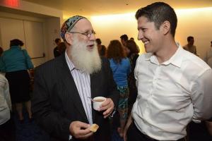 Two men are talking to each other at a party.