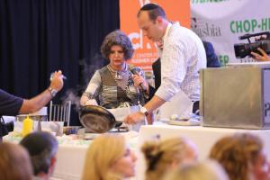 A man and woman shaking hands over a table.