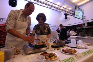 A group of people standing around plates on top of a table.