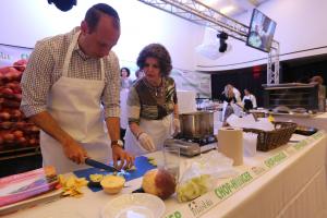 Two people chopping vegetables at cooking station
