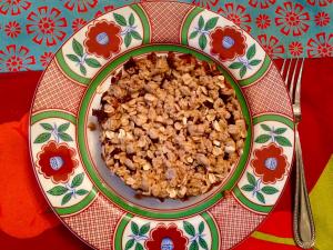A bowl of cereal on top of a colorful plate.