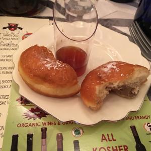 A plate with two bagels and one jelly donut.