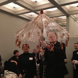 A group of people standing around holding an umbrella.