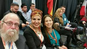 Two women in a group of people sitting next to each other.