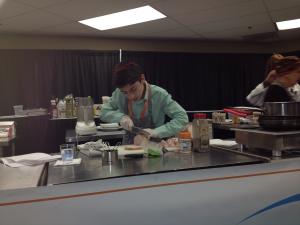 A man is working in the kitchen with some food.